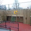Front view of St Christopher's adventure play structure with raised walkway and scramble net