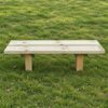 Backless timber bench with two seat planks on grass