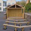 Covered timber stage fitted between existing stone walls with three rows of audience benches