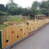 Rainbow picket fencing around a landscaped school play area