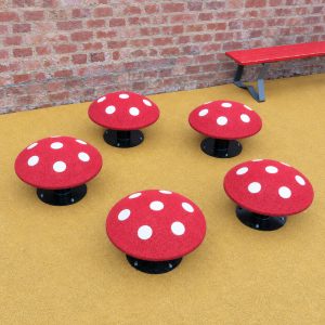 Five red and white mushroom seats on yellow playground surfacing