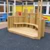 Open timber performance stage with shaped panels, circular details and built-in seating