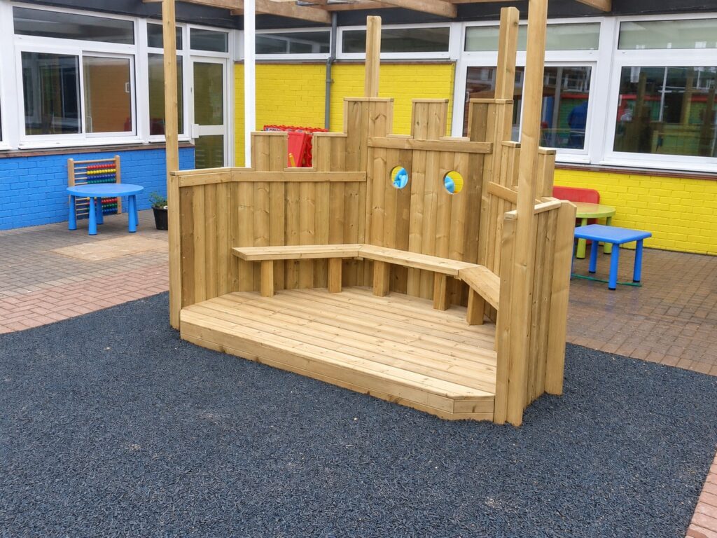 Open timber performance stage with shaped panels, circular details and built-in seating
