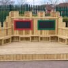 Open timber performance stage with two chalkboards and built-in benches