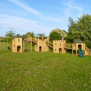 Four linked timber garden play structures with bridges, swings and a green slide