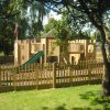 Timber adventure play installation at Godstowe with slide, bridge and fenced play area