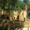 Godstowe tower and slide play structure with timber gatehouse and bridge
