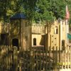 Gatehouse adventure play structure at Godstowe with tower, slide and timber fencing