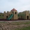 Side view of Gypsy Wood adventure play structure with slide and bridge
