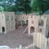 Installed Merlewood timber play structure with slide and fort towers