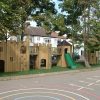 Oakdale timber castle play area with slide and linked towers