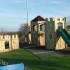 Side view of Skelton timber play towers and open slide