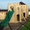 Skelton adventure play slide with climbing wall and timber towers
