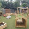 The Oval Primary School sensory play area with tunnel rainbow fencing planters and timber play features