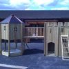 Front view of the Secret Life Playground Combo with slide, gatehouse, bridge and climbing den