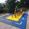 Four Acres Academy school playground with timber play frame roadway markings and coloured wet-pour surfacing
