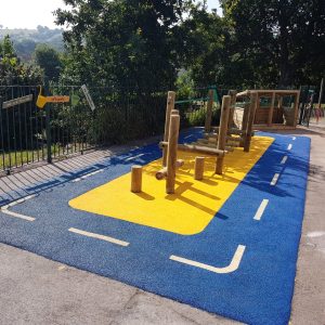 Four Acres Academy school playground with timber play frame roadway markings and coloured wet-pour surfacing