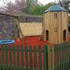 The Royal fenced playground with play tower slide group swing and rubber safety surfacing