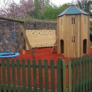 The Royal fenced playground with play tower slide group swing and rubber safety surfacing