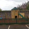 The Royal compact fenced play area with tower slide and group swing