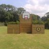 Side view of wooden multi-use goals on a grass play area