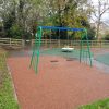 Down Road swing frame with bonded rubber mulch surfacing and play area fencing