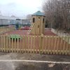 Sutherland Quarters fenced community playground with tower slide carousel and coloured rubber mulch surfacing