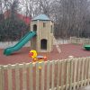 Sutherland Quarters play tower and slide with spring rocker in a fenced community play area
