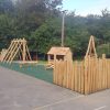 Kings Stanley natural play area with timber stockade scramble pyramid and green rubber mulch surfacing