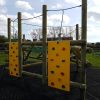 Clamber stack with yellow climbing panels and timber frame