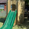 Front view of playground turret with slide and timber platform
