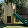 Playground turret with slide and ladder installed on safety surfacing