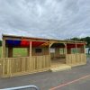 Wide view of Rainbow Roof Outdoor Classroom in an outdoor learning area