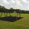 Wide view of timber playground swings with safety surfacing