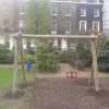 Timber playground swing frame in shared outdoor space