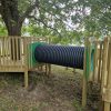Crawl tunnel between raised timber tree play platforms