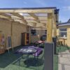 Covered school play area beneath a timber canopy at Bussage