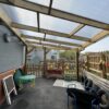 Tables and play resources beneath a timber school canopy at Twyning